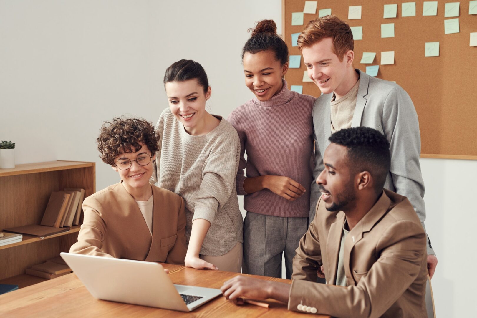 A group of friends checking a laptop